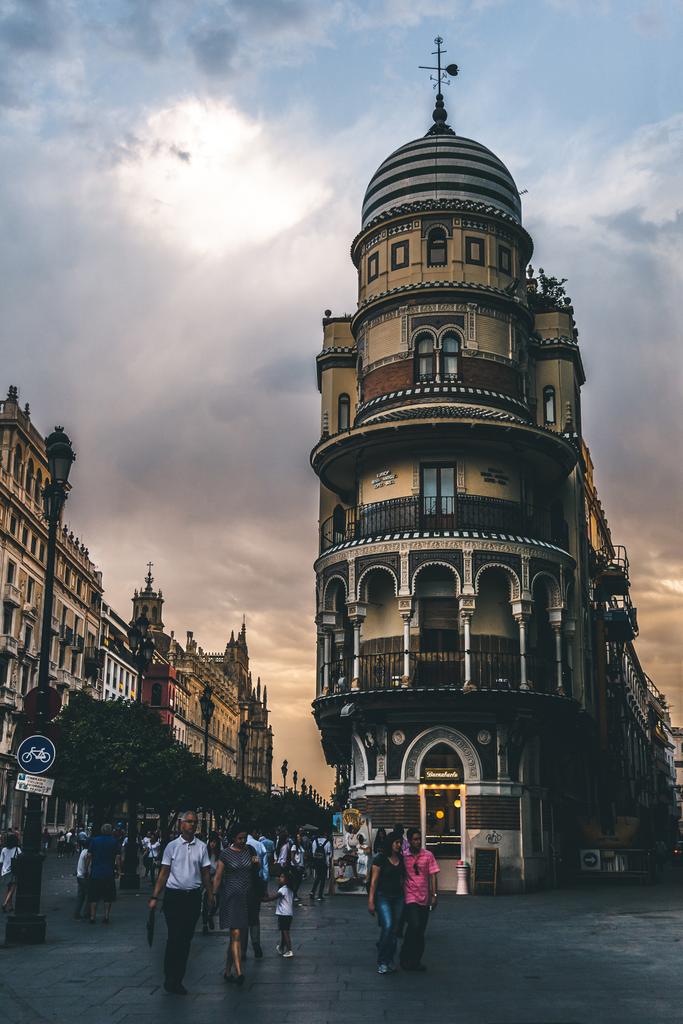 Gyönyörű kilátás a városi utcára az emberekkel az esti órákban, Sevilla, Spanyolország - Fotó, kép