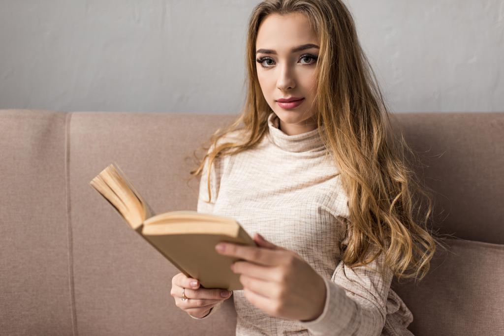 atractiva joven leyendo libro en el sofá
 - Foto, Imagen