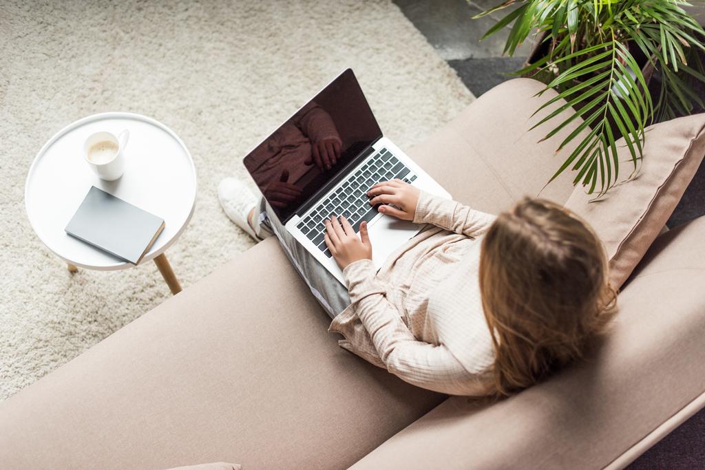 korkea kulma näkymä nuori nainen työskentelee kannettavan tietokoneen kotona
 - Valokuva, kuva