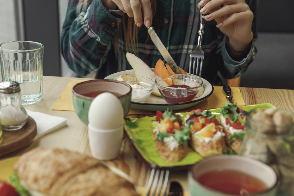 visão parcial da pessoa que come café da manhã saboroso saudável
  - Foto, Imagem