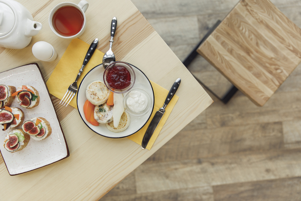 bovenaanzicht van het gezond ontbijt met thee set op houten tafel   - Foto, afbeelding