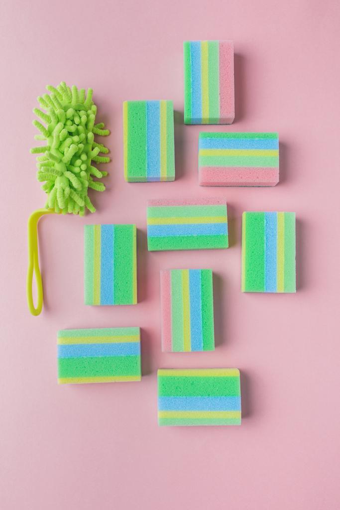 vista superior de esponjas de lavagem coloridas e escova, em rosa
 - Foto, Imagem