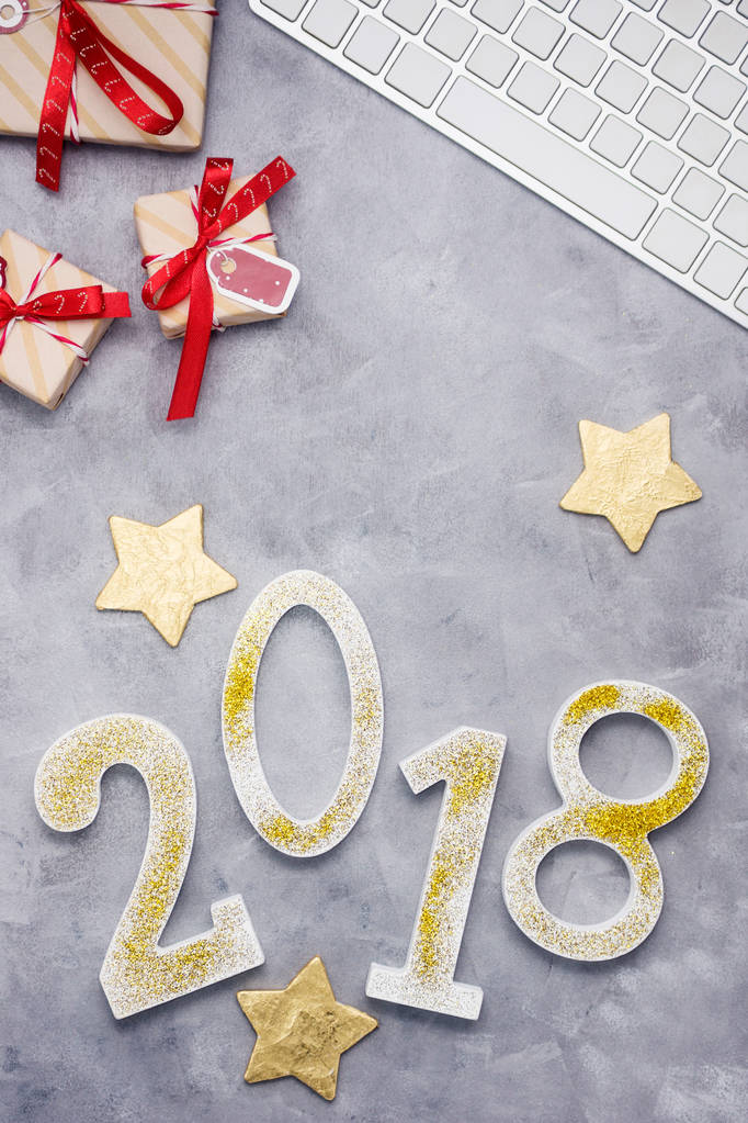 Роскошные блестящие номера 2018 года с клавиатурой и подарками на сером бетонном фоне. Новогодняя концепция. Текстовое пространство
 - Фото, изображение