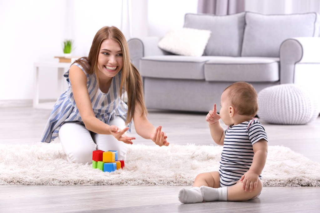 Nuori äiti ja söpö vauva leikkii lattialla kotona
 - Valokuva, kuva