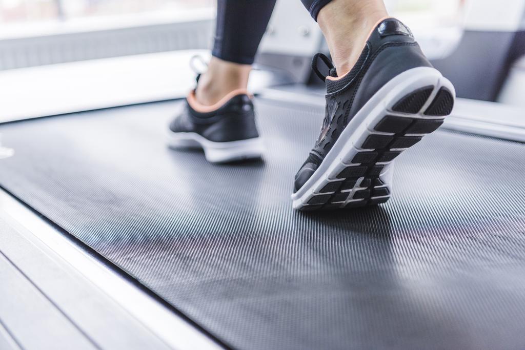 ritagliato colpo di donna in jogging sneakers corsa sul tapis roulant
 - Foto, immagini