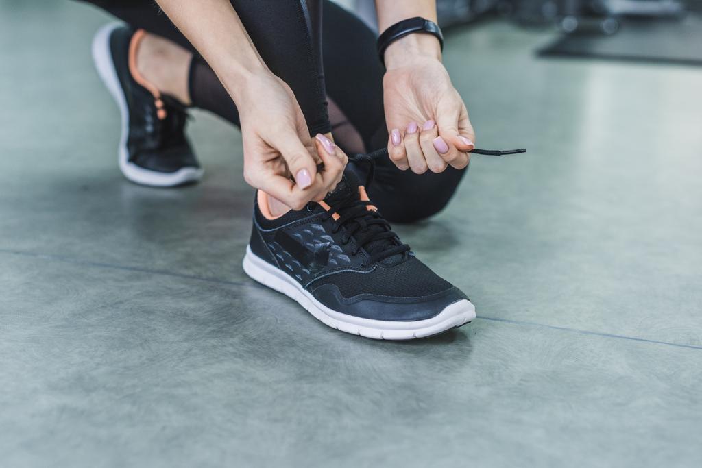 recortado tiro de mujer atando zapatillas de deporte antes de entrenar
 - Foto, imagen