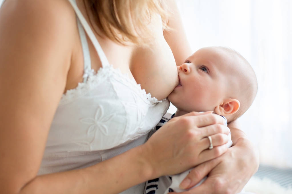 Jonge moeder borstvoeding haar pasgeboren babyjongen - Foto, afbeelding