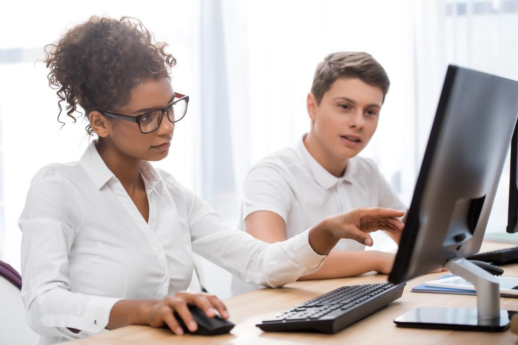Jugendliche Studenten zeigen auf Bildschirm des Computers - Foto, Bild