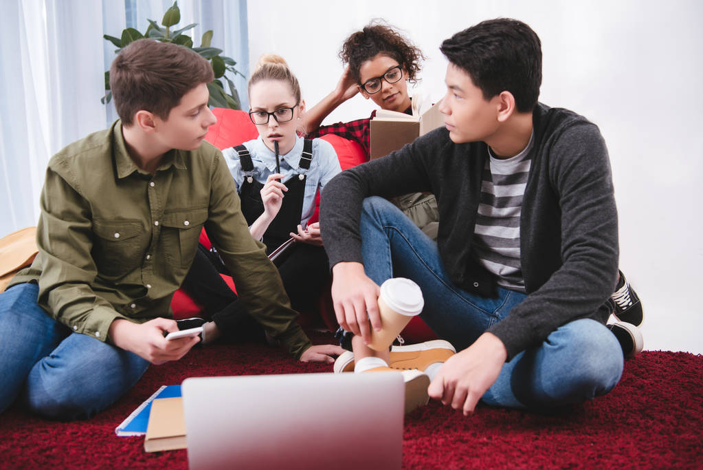 adolescentes multiculturais estudando com laptop e cadernos
 - Foto, Imagem
