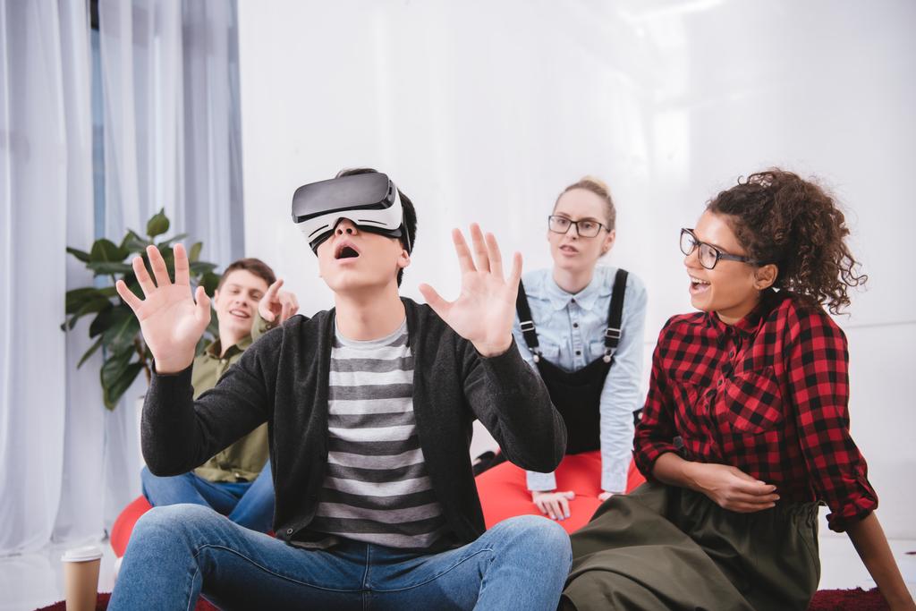 menino em óculos de realidade virtual sentado no tapete com amigos
 - Foto, Imagem