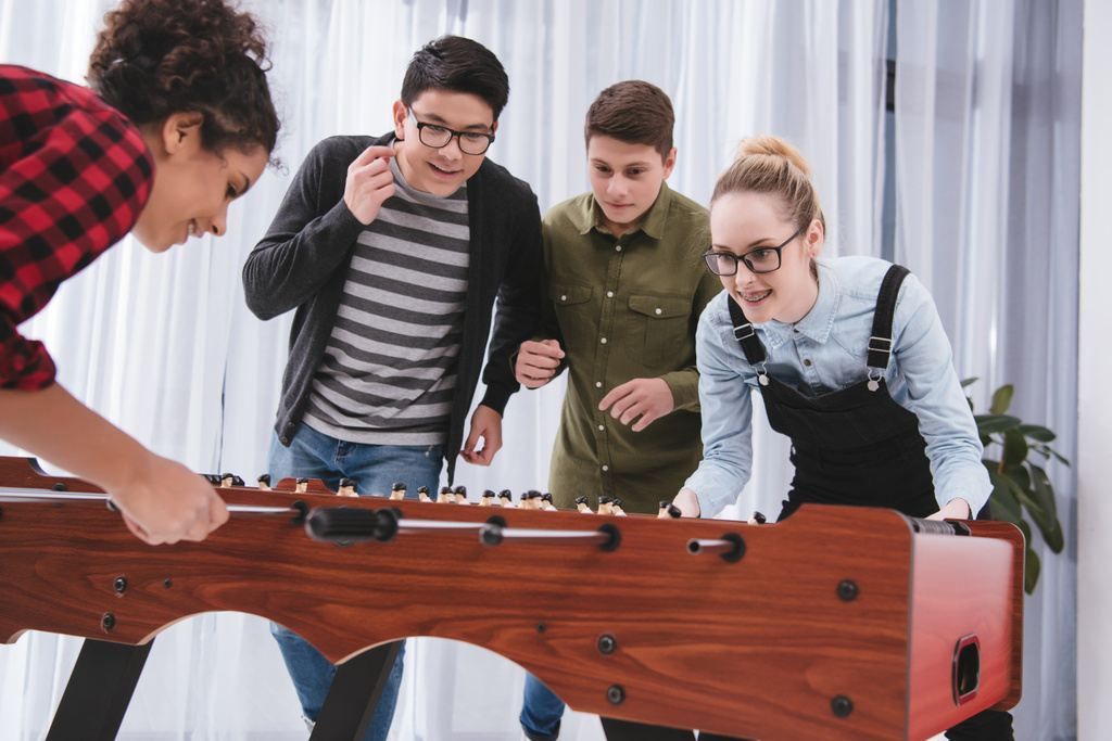happy cheerful teenagers playing in table soccer - Photo, Image