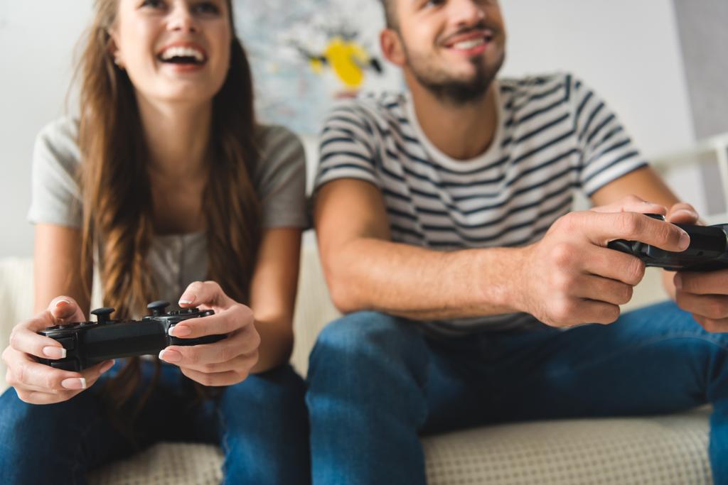 close-up tiro de jovem casal jogando jogos com gamepads em casa
 - Foto, Imagem