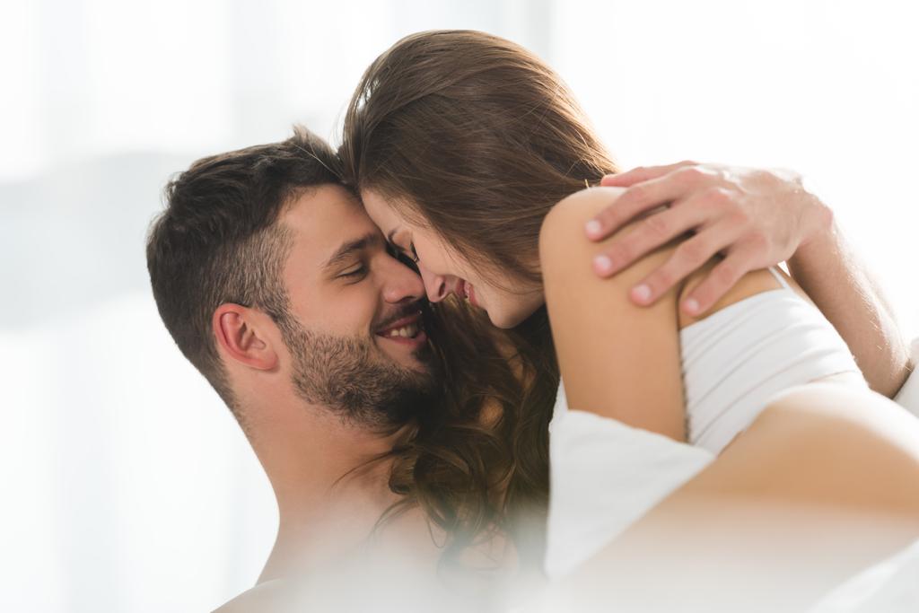 jeune couple souriant et embrassant au lit le matin
 - Photo, image