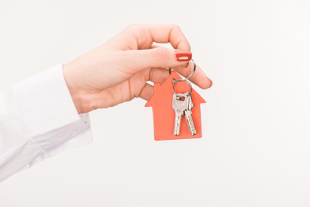 cropped image of female hand holding key from house isolated on white - Photo, Image