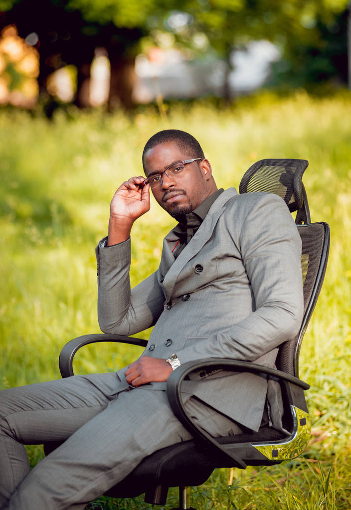 Jeune homme d'affaires afro-américain au travail dans le parc. Concept de télétravail
. - Photo, image