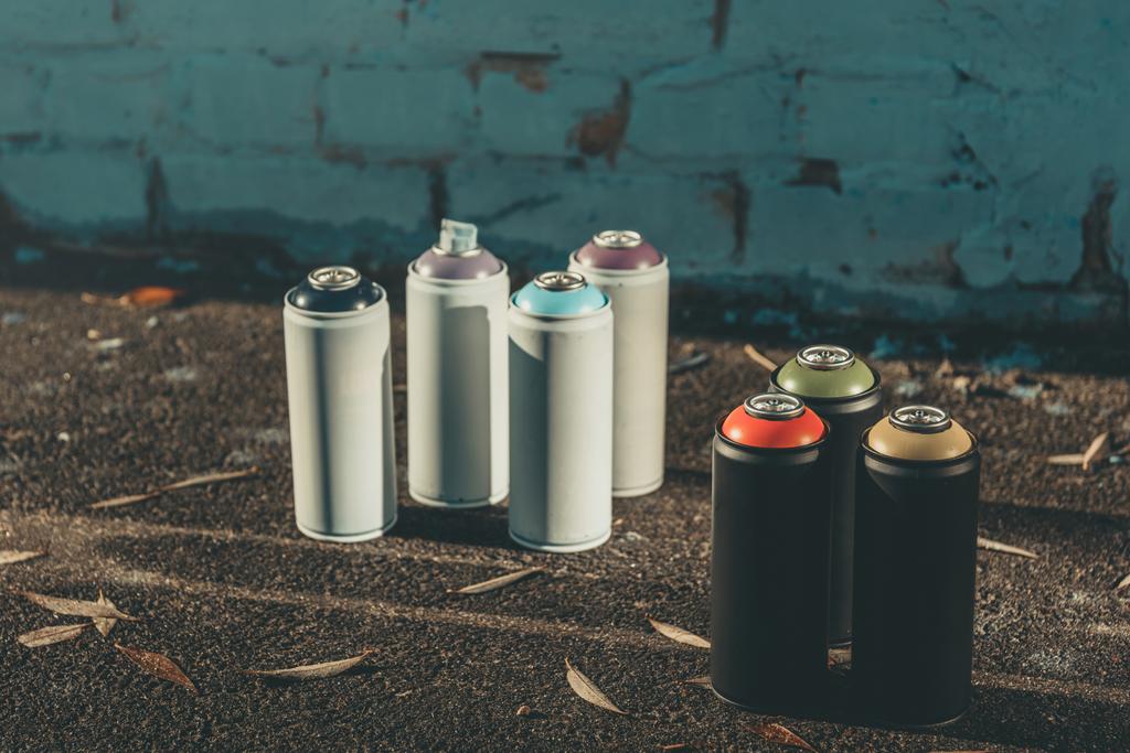 банки с красочной краской для граффити на асфальте
 - Фото, изображение