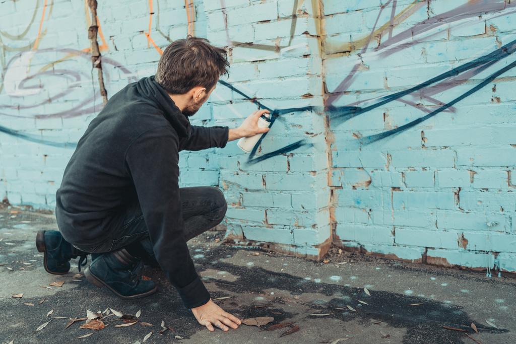 уличный художник рисует красочные граффити на стене здания
 - Фото, изображение
