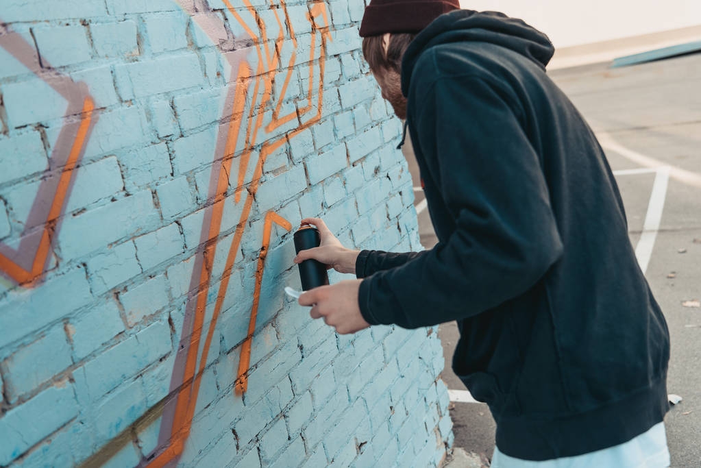 καλλιτέχνης δρόμου ζωγραφική πολύχρωμα γκράφιτι στον τοίχο του κτιρίου - Φωτογραφία, εικόνα