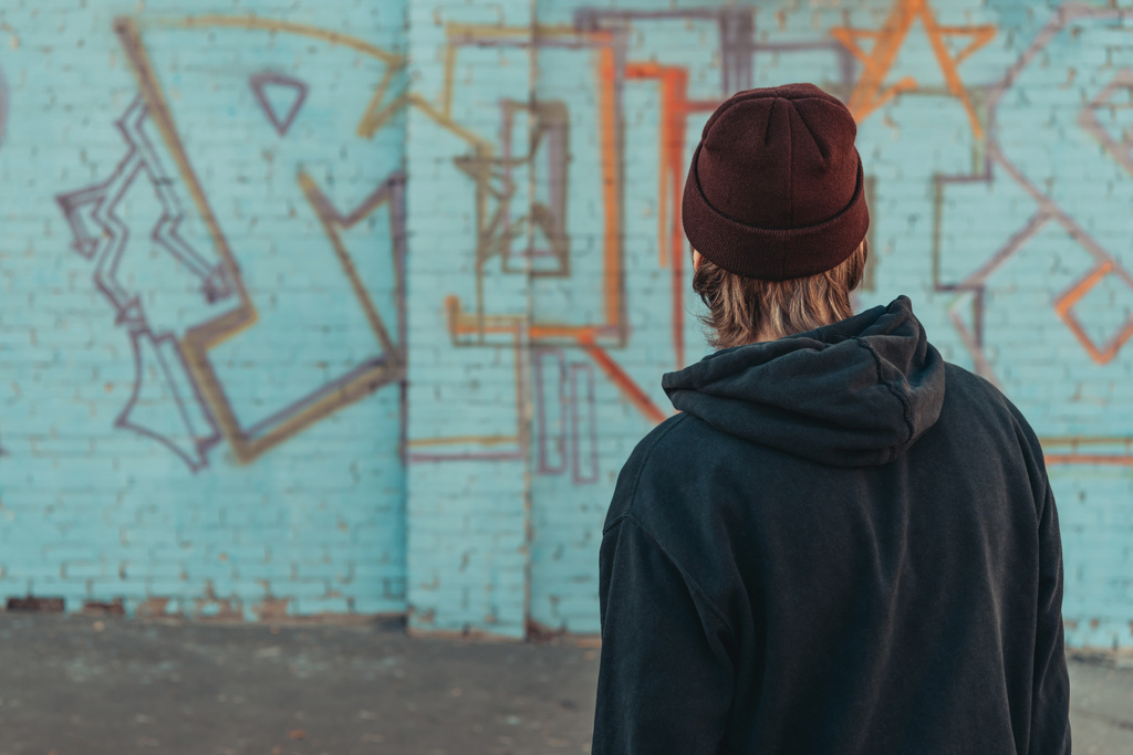 zadní pohled na člověka dívá na barevné graffiti na zdi - Fotografie, Obrázek