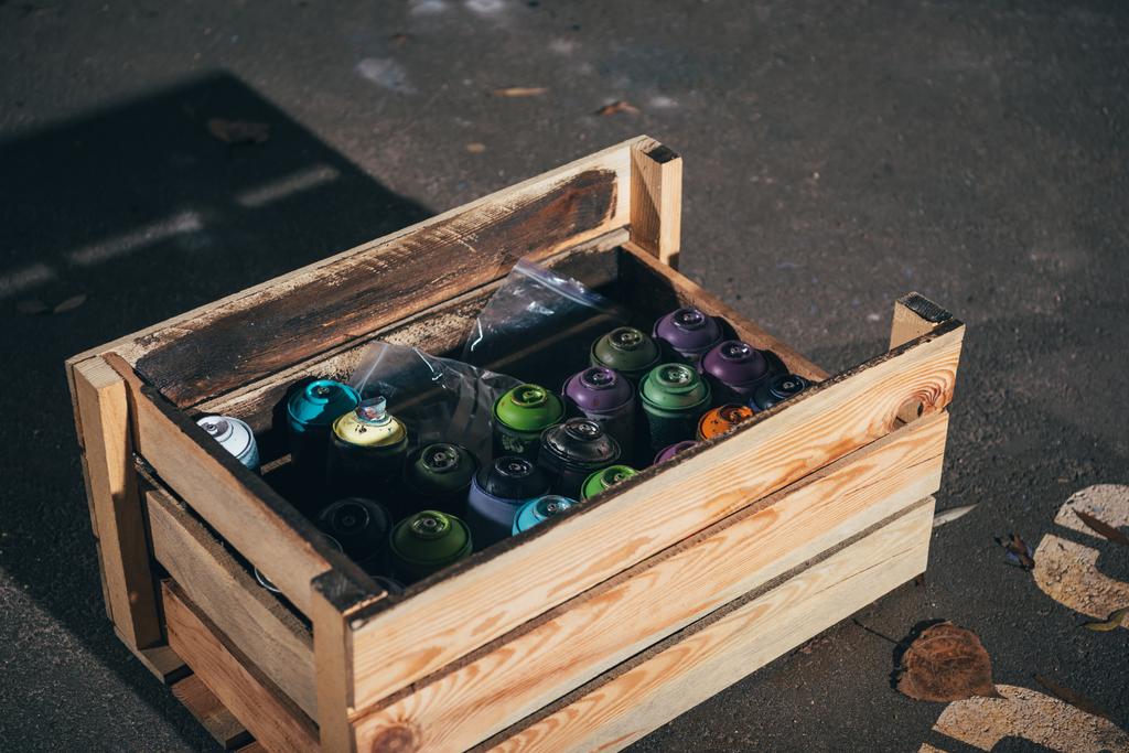 latas con pintura en aerosol en caja de madera
 - Foto, Imagen