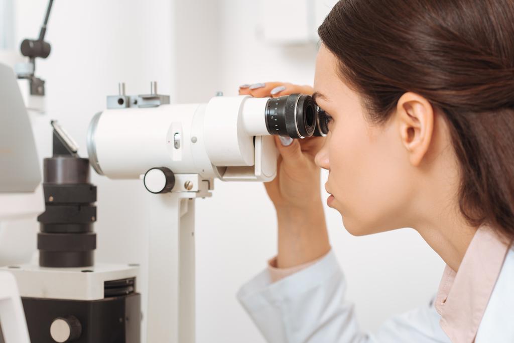 vue latérale de l'optométriste professionnel travaillant avec la lampe à fente dans la clinique
 - Photo, image