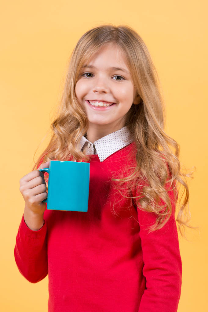 Dětský úsměv s modrým pohárem na oranžovém pozadí - Fotografie, Obrázek