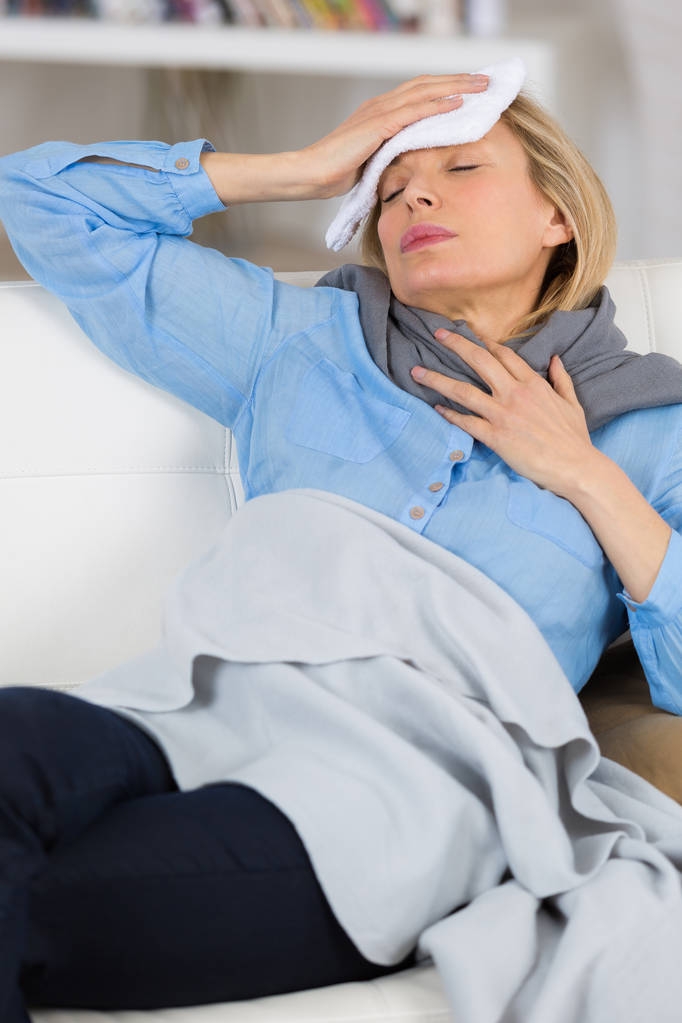 больная женщина с головной болью лежит на диване
 - Фото, изображение