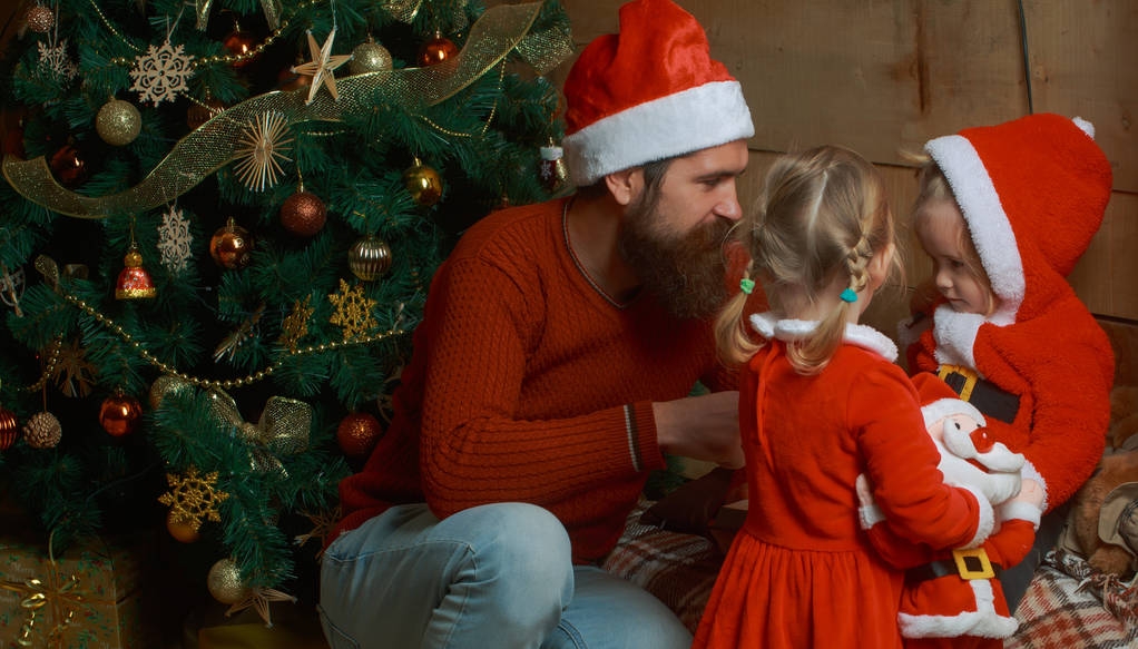 ひげを生やした父とサンタ帽子の子供たちのクリスマスの家族 - 写真・画像