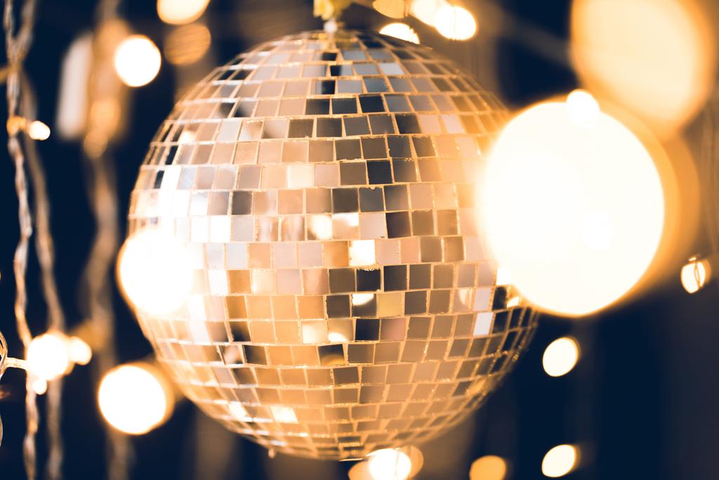 золотий глянсовий диско-куля з різдвяними вогнями навколо
 - Фото, зображення