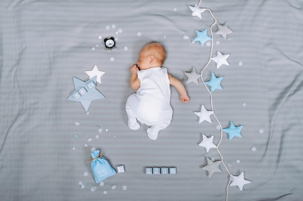 вид сверху на очаровательного спящего младенца с украшениями вокруг
 - Фото, изображение