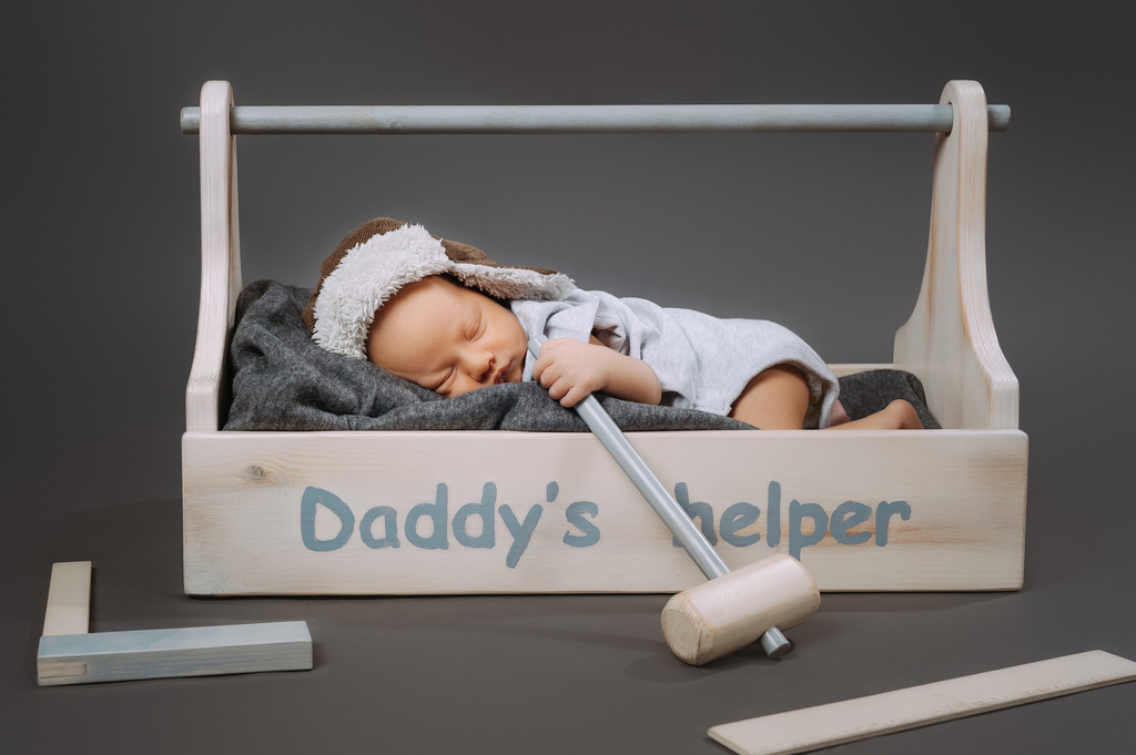 adorabile bambino con martello in mano dormire in cassetta degli attrezzi di legno con daddys helper lettering
 - Foto, immagini