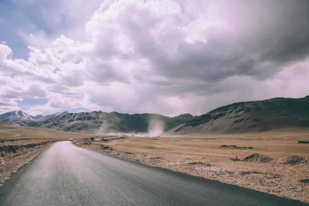 pustą asfaltową drogą w górskiej dolinie i pochmurnego nieba w indyjskich Himalajach Ladakhu  - Zdjęcie, obraz