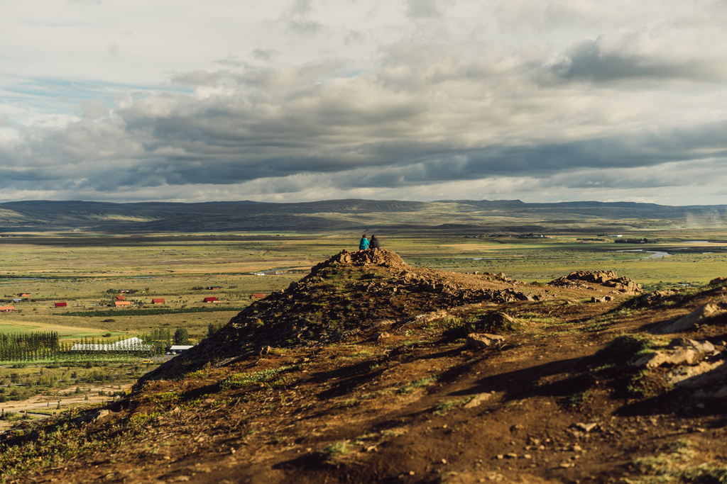 takaisin näkymä pari istuu kalliolla ja katselee luonnonkaunis villi maisema Islannissa
  - Valokuva, kuva