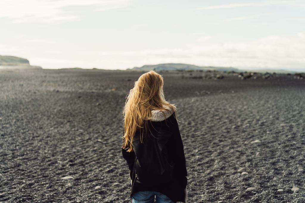 arkadan görünüşü güzel vahşi İzlanda manzara arayan genç kadın - Fotoğraf, Görsel