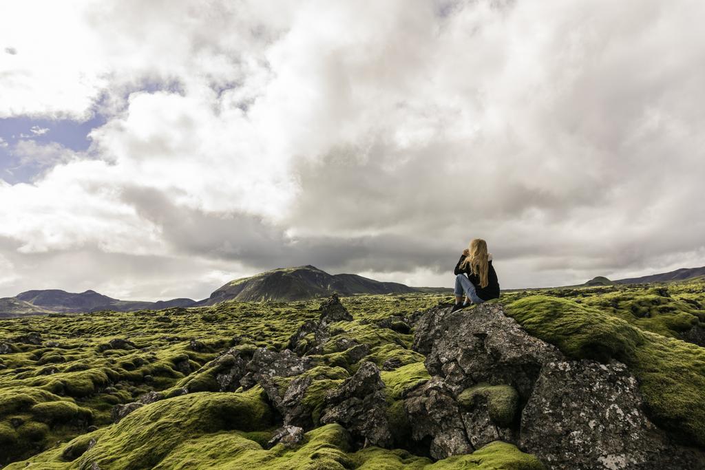 joven sentada en la roca y mirando majestuoso paisaje icelandés
 - Foto, Imagen