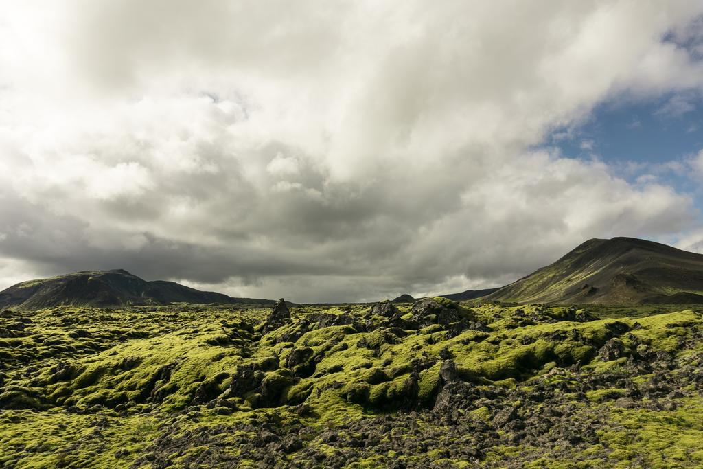 величественный пейзаж с горами, мхом и облачным небом в Исландии
   - Фото, изображение