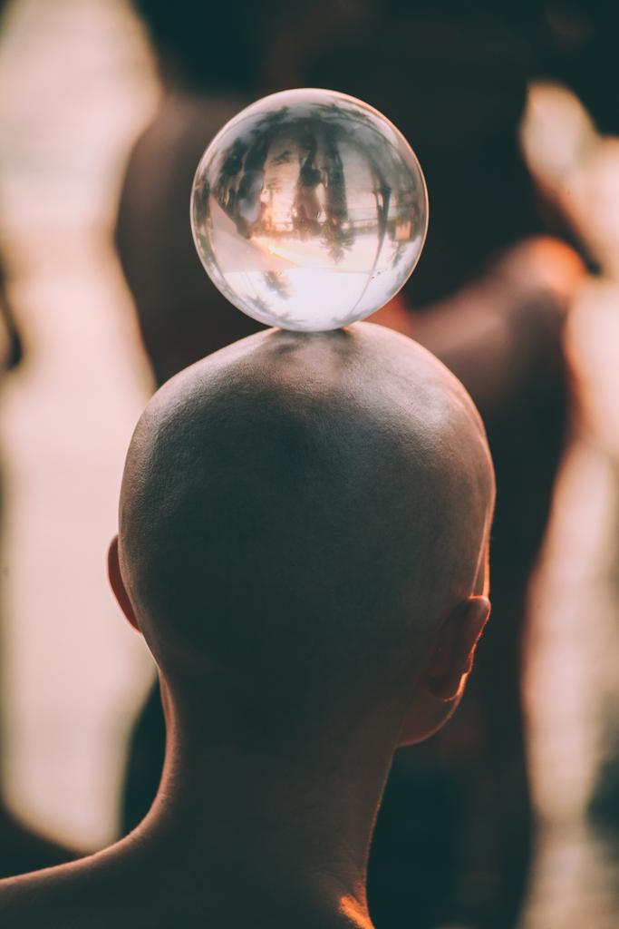 крупным планом вид сзади на молодого человека, стоящего со стеклянным шаром на голове, Гоа
 - Фото, изображение