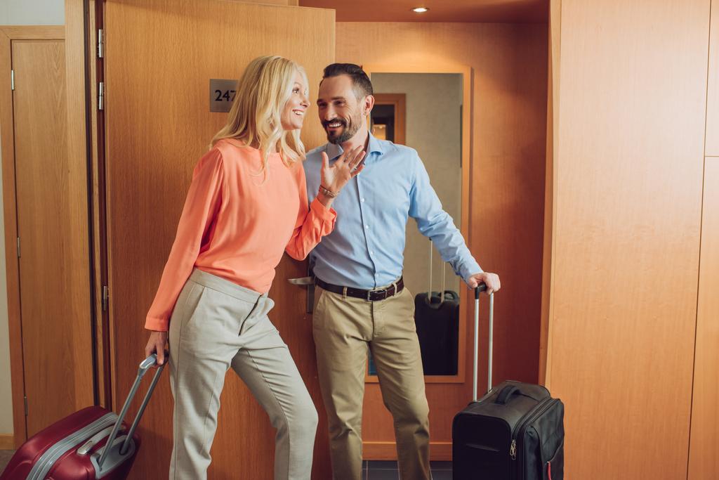 boldog érett pár, a szállodai szobában nevetve bőröndök  - Fotó, kép