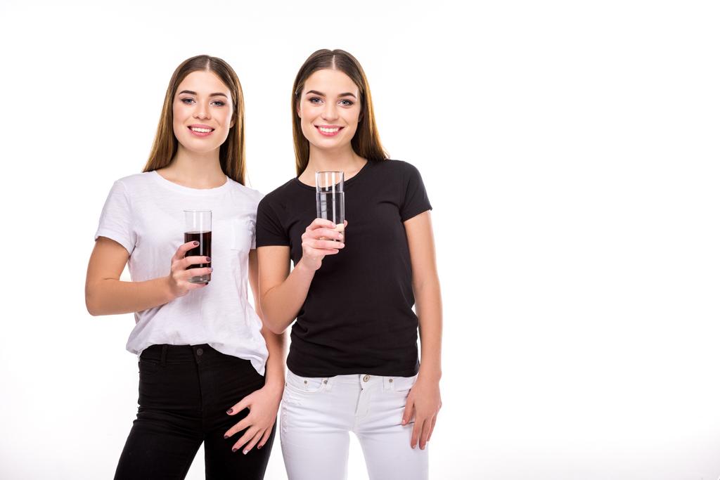 портрет веселих близнюків, що тримають келихи содової та води в руках ізольовані на білому
 - Фото, зображення