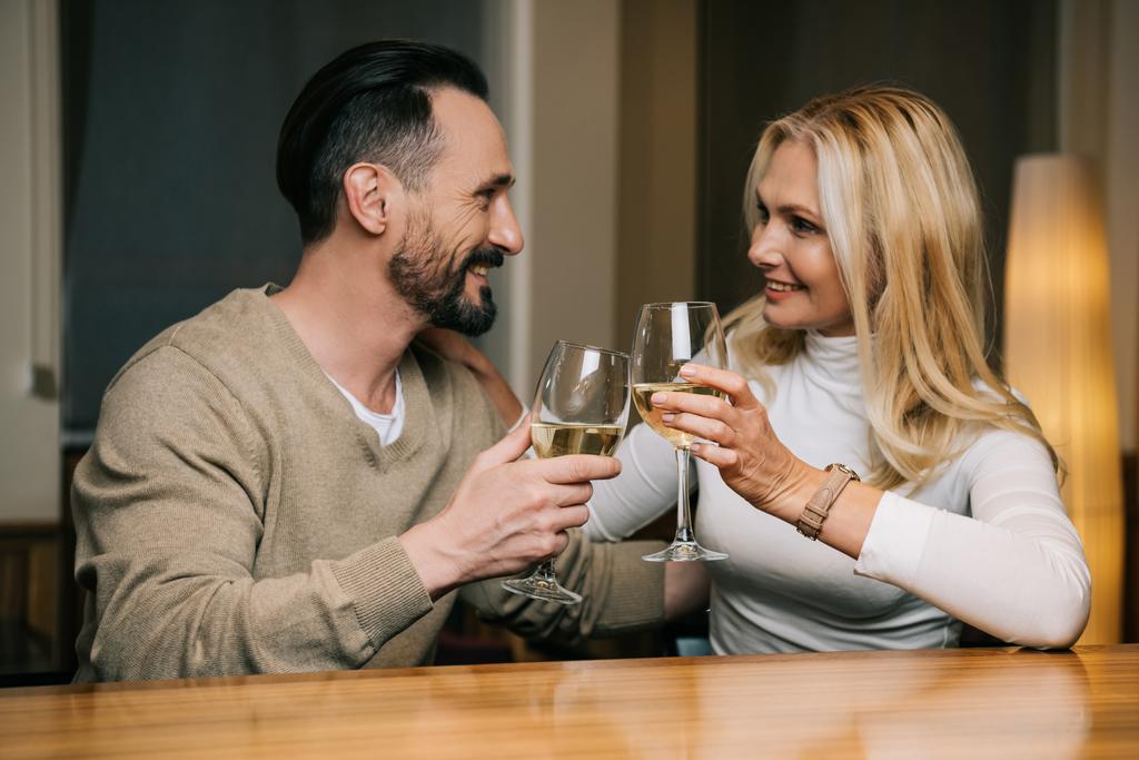 szczęśliwa para Dorosła picia wina i uśmiechając się nawzajem w restauracji hotelu   - Zdjęcie, obraz