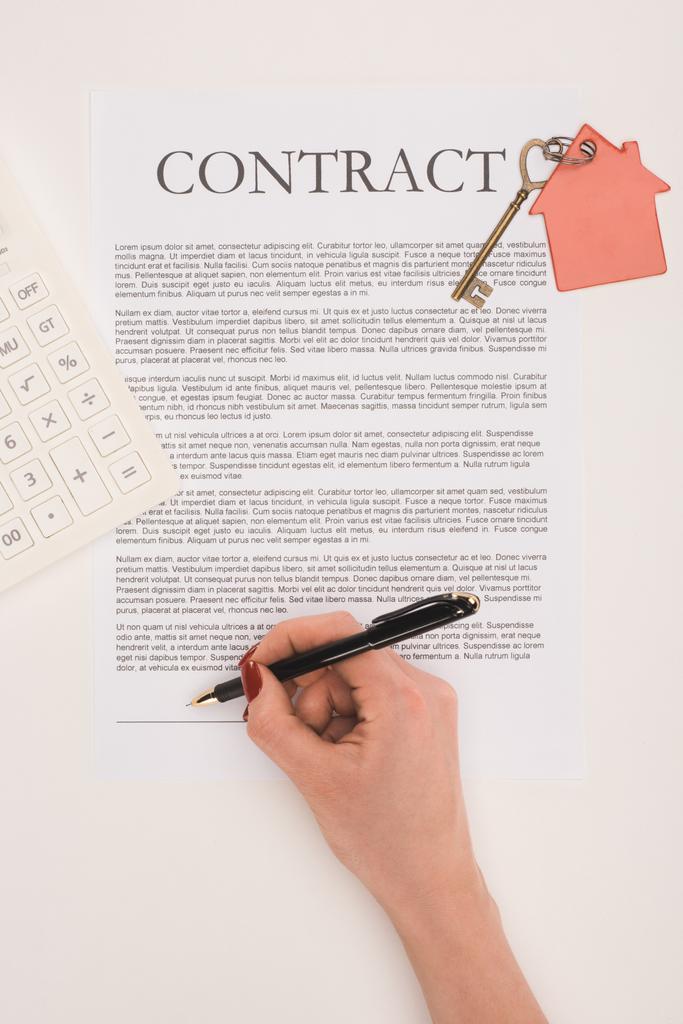 bovenaanzicht van bijgesneden hand tekent contract voor het kopen van huis geïsoleerd op wit - Foto, afbeelding