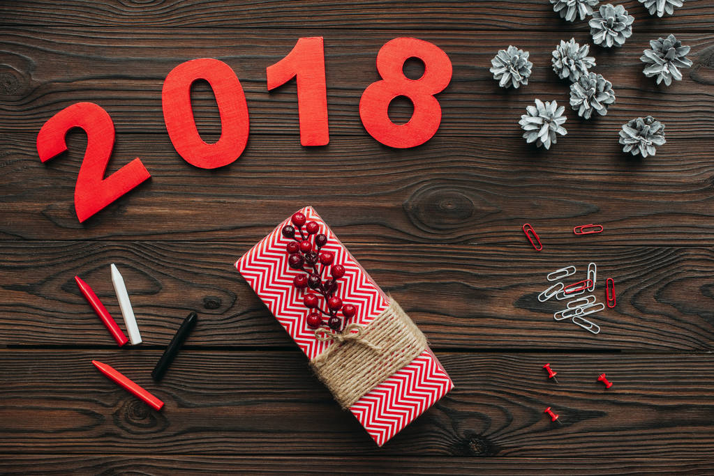 flat lay with christmas gifts, pine cones and 2018 year sign on dark wooden tabletop - Photo, Image