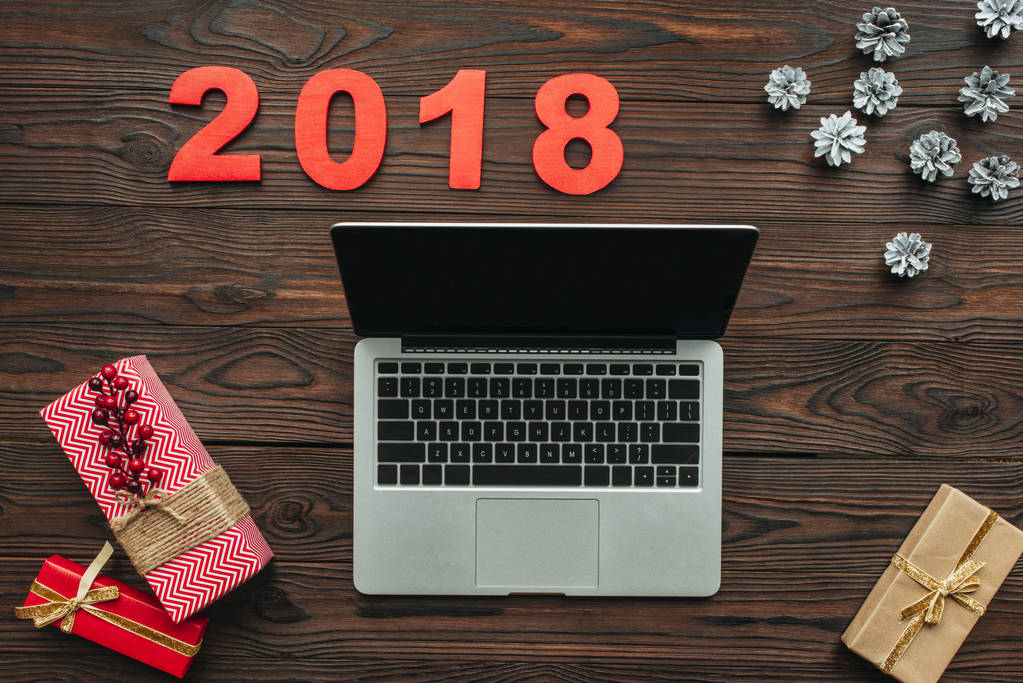 dizüstü bilgisayar, sarılmış hediyeler ve 2018 numaraları ahşap yüzey üzerinde düz lay - Fotoğraf, Görsel