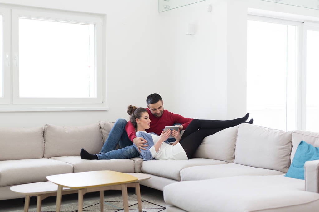 pareja relajante en casa con tabletas
 - Foto, Imagen