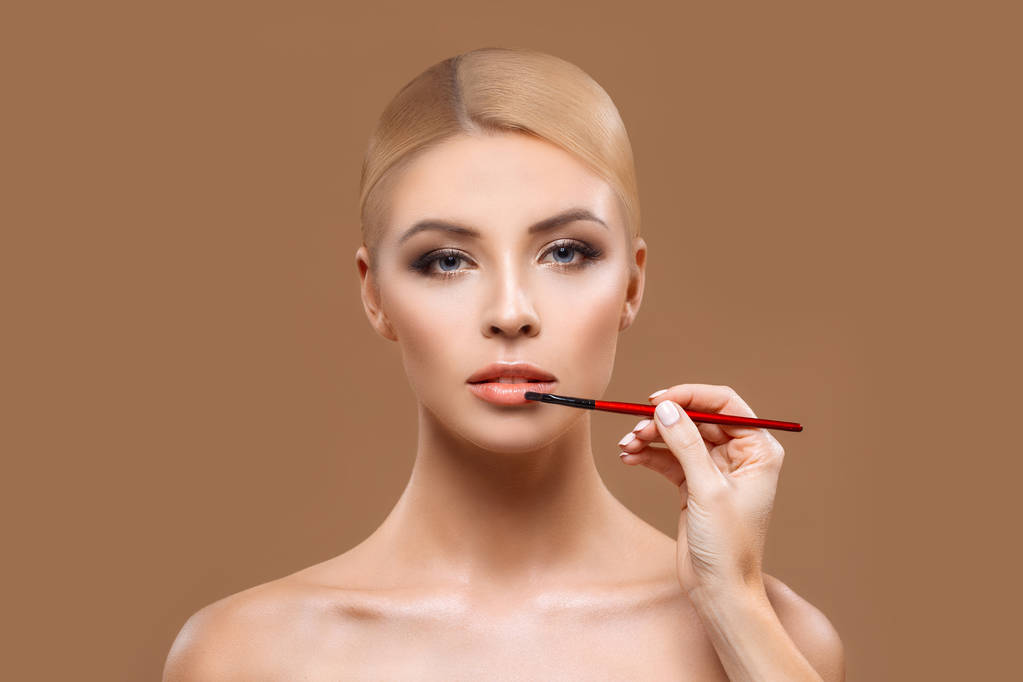 mujer aplicando lápiz labial rojo - Foto, Imagen