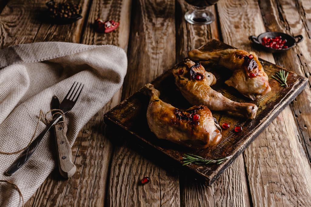 lezzetli ızgara tavuk ayakları üzerinde ahşap tahta çatal bıçak takımı ile yakın çekim çekim - Fotoğraf, Görsel