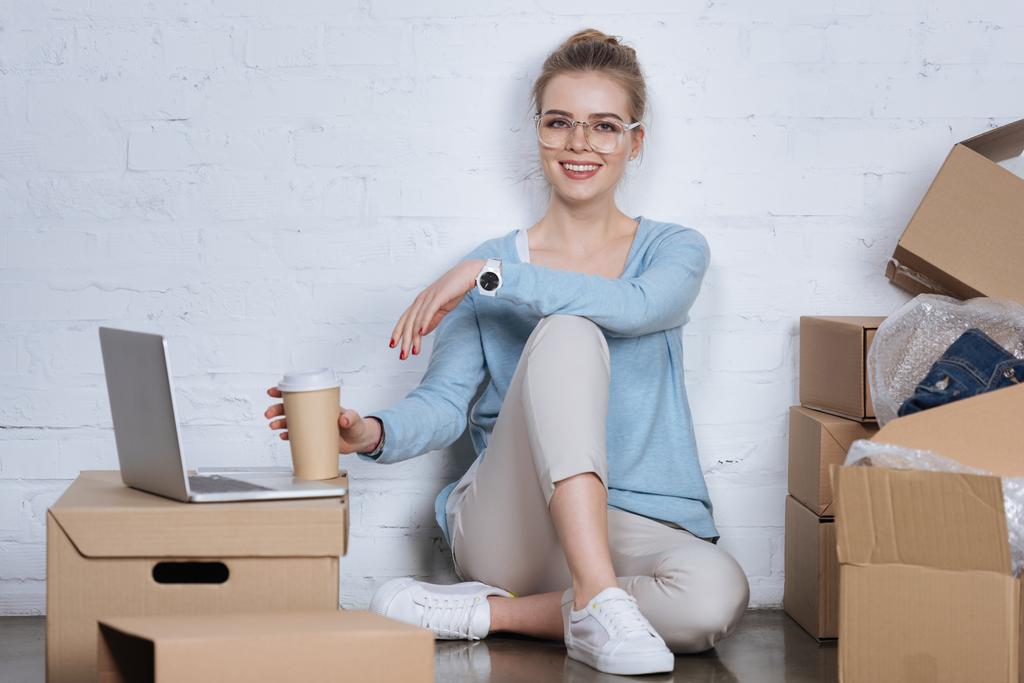 オフィス、自宅の床に座って移動するコーヒーと笑顔起業家 - 写真・画像