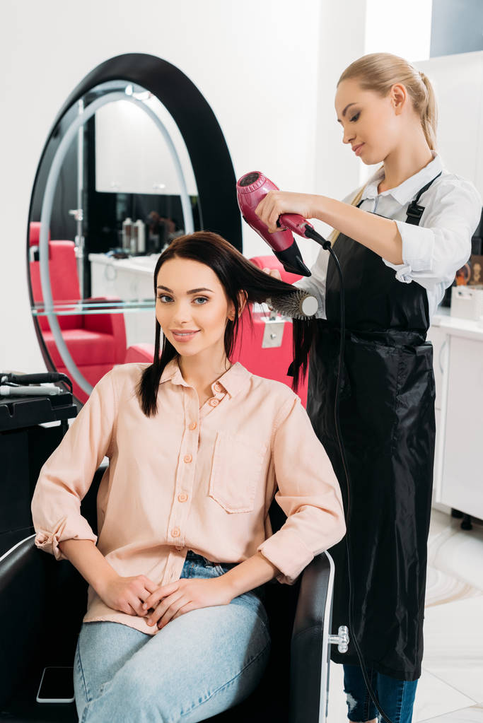 перукар сушіння волосся клієнтів в салоні
 - Фото, зображення