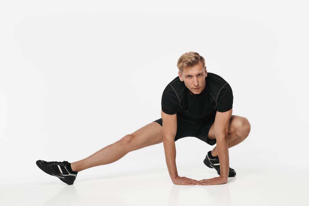Deportista confiado flexionando en blanco
 - Foto, imagen