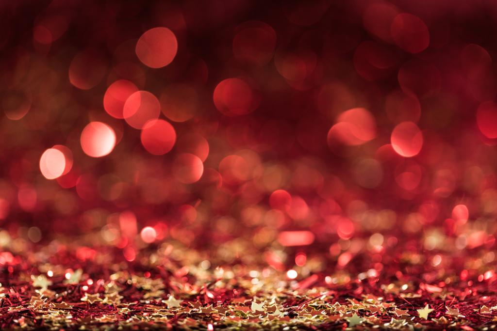Kerstmis achtergrond met rode glanzende confetti sterren - Foto, afbeelding